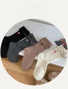 Détail de quatre paires de chaussettes en coton avec broderie et bords roulés