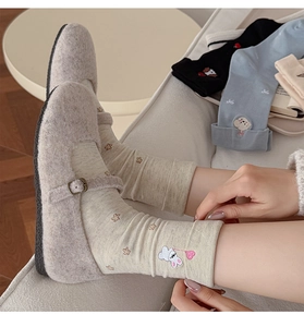 Close-up of beige knit socks with cute rabbit embroidery and retro Mary Jane shoes