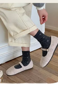 Detail of gray floral knit socks paired with beige suede Mary Jane shoes and corduroy pants