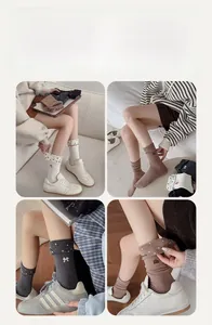 Détail de motifs brodés de nœuds et fraises sur des chaussettes en coton à revers