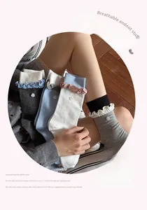 Detail showing wavy ruffled edges and heart buttons on colorful cotton mid-calf socks