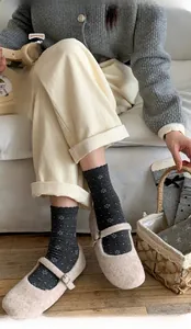 Cozy grey mid-calf socks with white polka dots and floral patterns worn with Mary Janes