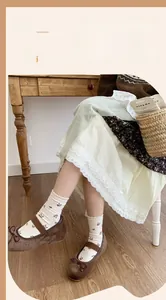 Close-up of floral crew socks with scalloped edges and retro patterns on model feet