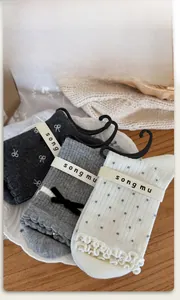 Détails de chaussettes grises à nœuds et pois présentées sur une table en bois rustique