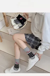 Detail of preppy style mid-calf socks with striped patterns and cute dog embroidery