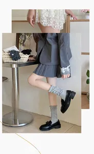 Gray slouch socks with ruffle trim styled with pleated skirt and black platform loafers