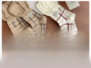 Close-up of vintage plaid cotton socks with knit texture and MiMoRSTUDIO woven label