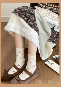 Detail of vintage floral knit mid-calf socks with ruffle trim and Mary Jane shoes