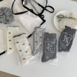Five pairs of women's bow tie mid-calf socks with ruffle cuffs in neutral tones