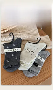 Détail de trois paires de chaussettes en coton gris et blanc avec nœuds et motifs à pois