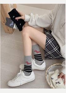 Close-up of cute sausage dog embroidery and stripe details on knitted cotton mid-calf socks
