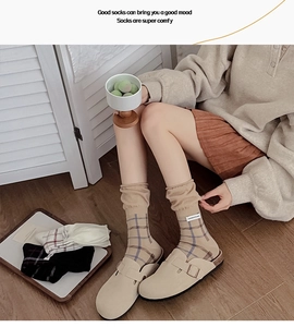 Detail of vintage khaki plaid crew socks with a stylish woven label and slouchy cuff