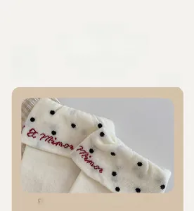 Détail macro du bord élastique souple avec broderie rouge sur chaussettes à pois