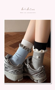 Detailed view of color-block ruffle trim crew socks with heart button accents and ribbing