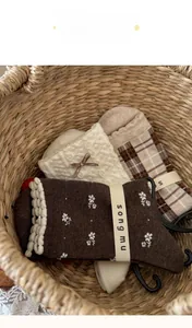 Detail of three vintage floral and plaid cotton socks set with lace and bow accents