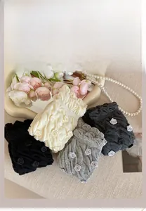 Detailed color display of knit hair scrunchies with 3D roses in grey, black and beige