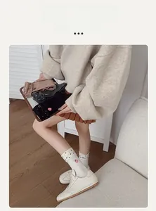 Détail de chaussettes en maille avec broderie fraise et accents de nœuds doux