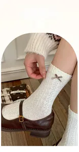 Detailed view of white lace crew socks featuring a brown silk bow and vintage floral pattern