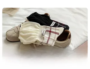 Detail of plaid cotton crew socks in black and cream on vintage sneakers