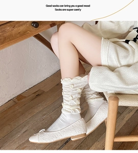 Detailed shot of white slouch socks with 3D rose flower accents and mesh texture