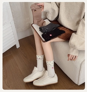 Détail de chaussettes en coton avec revers à pois et broderie fraise mignonne
