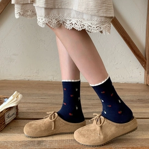 Navy blue crew socks with floral patterns and white lace trim in vintage mule shoes
