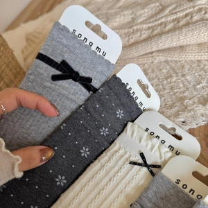 Gray and beige knit socks with bows and floral patterns in a cozy winter style