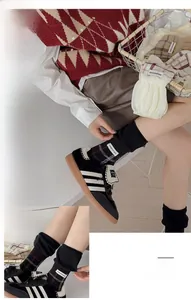 Detail of retro plaid crew socks with woven label paired with stylish sneakers and skirt