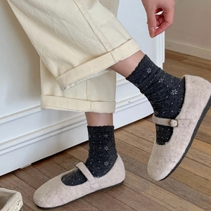 Gray socks with white floral pattern and lace trim worn with fuzzy Mary Jane shoes