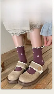 Detail of purple cotton mid-tube socks with floral embroidery and wavy lace trim