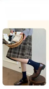 Detail of ribbed knit crew socks featuring button trim and bow accent in various colors