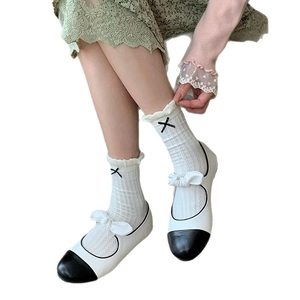 Gray crew socks with lace trim and bow knot detail worn with bicolor Mary Jane shoes
