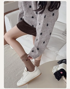 Détail de la broderie de gâteau et des pois blancs sur les chaussettes en coton marron