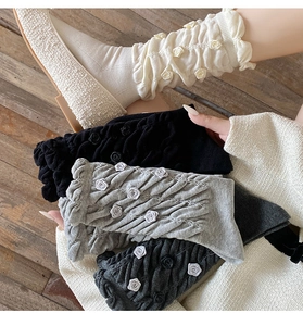 Detail of sweet knit slouch socks with 3D roses, pleated texture and ruffle trim
