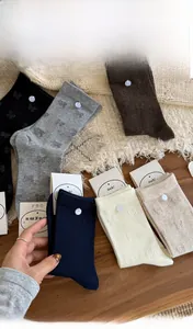 Close-up of premium cotton mid-calf socks with elegant knitted bow patterns in various colors
