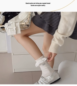 Détail de chaussettes blanches à volants avec broderie et nœuds délicats