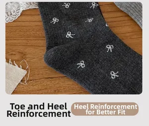 Gros plan sur le talon renforcé de chaussettes grises avec motifs petits nœuds blancs