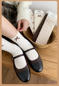 Close-up of Japanese-style floral crew socks with ribbon bows and lace trim details