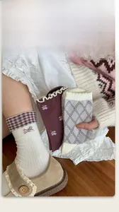 Detailed view of knitted cotton socks with floral embroidery and purple bow accents