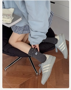 Détail de chaussettes gris foncé avec pois blancs et broderie nœud élégante