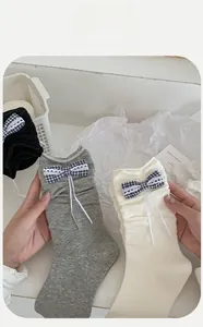 Close-up of cotton socks with lace trim and blue checkered bow detail