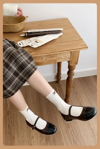 Detail of vintage floral crew socks with ribbon bow, lace trim and Mary Jane shoes