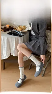 Gros plan de chaussettes blanches à nœuds bleus et bordure grise à volants élégants
