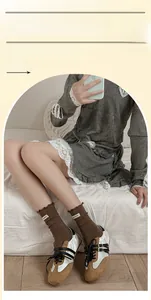 Détail de chaussettes marron côtelées à bord ondulé et étiquette avec baskets rétro