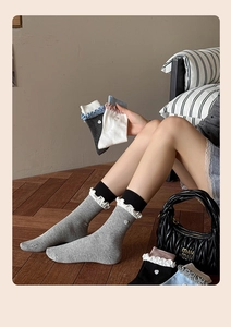 Detailed close-up of frilly lace cuffs and heart button accents on cotton crew socks