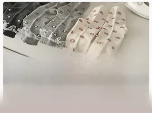 Detail of lace trim crew socks with pearl beads and sweet bow patterns in grey and white