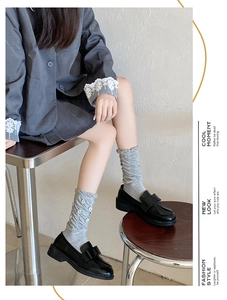Detail of grey slouch socks with white 3D flower applique and stylish ruffled cuff