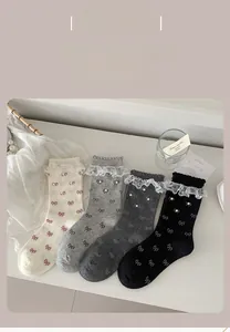 Detail of lace trim crew socks in four colors with pearl accents and bow patterns