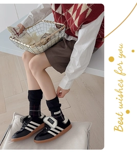 Close-up of vintage black and white plaid socks paired with retro sneakers and outfit
