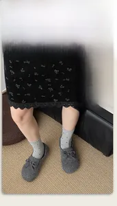 Chaussettes grises à fleurs portées avec mocassins en feutre et jupe en dentelle
